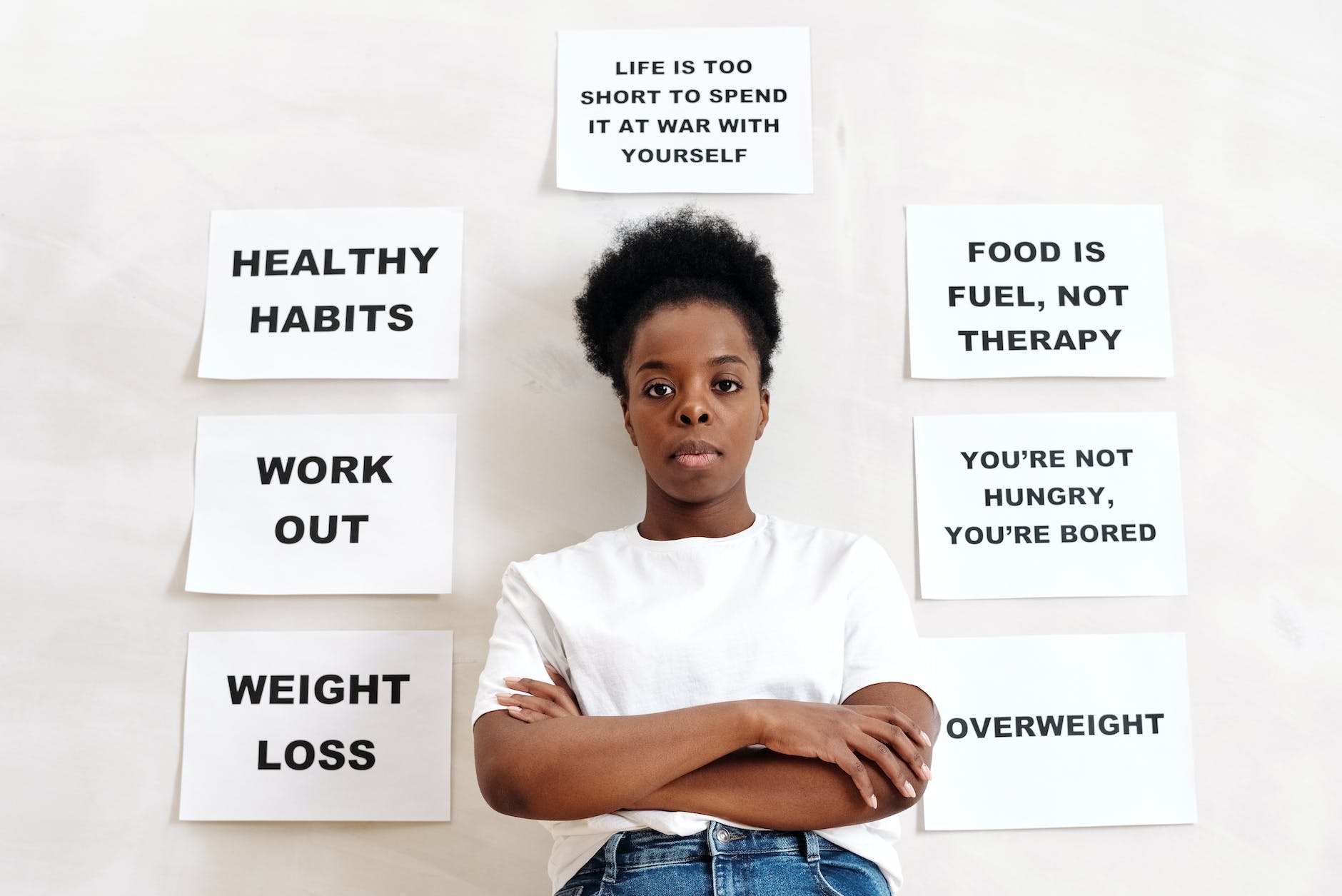 woman in white crew neck t shirt standing beside a wall with slogans